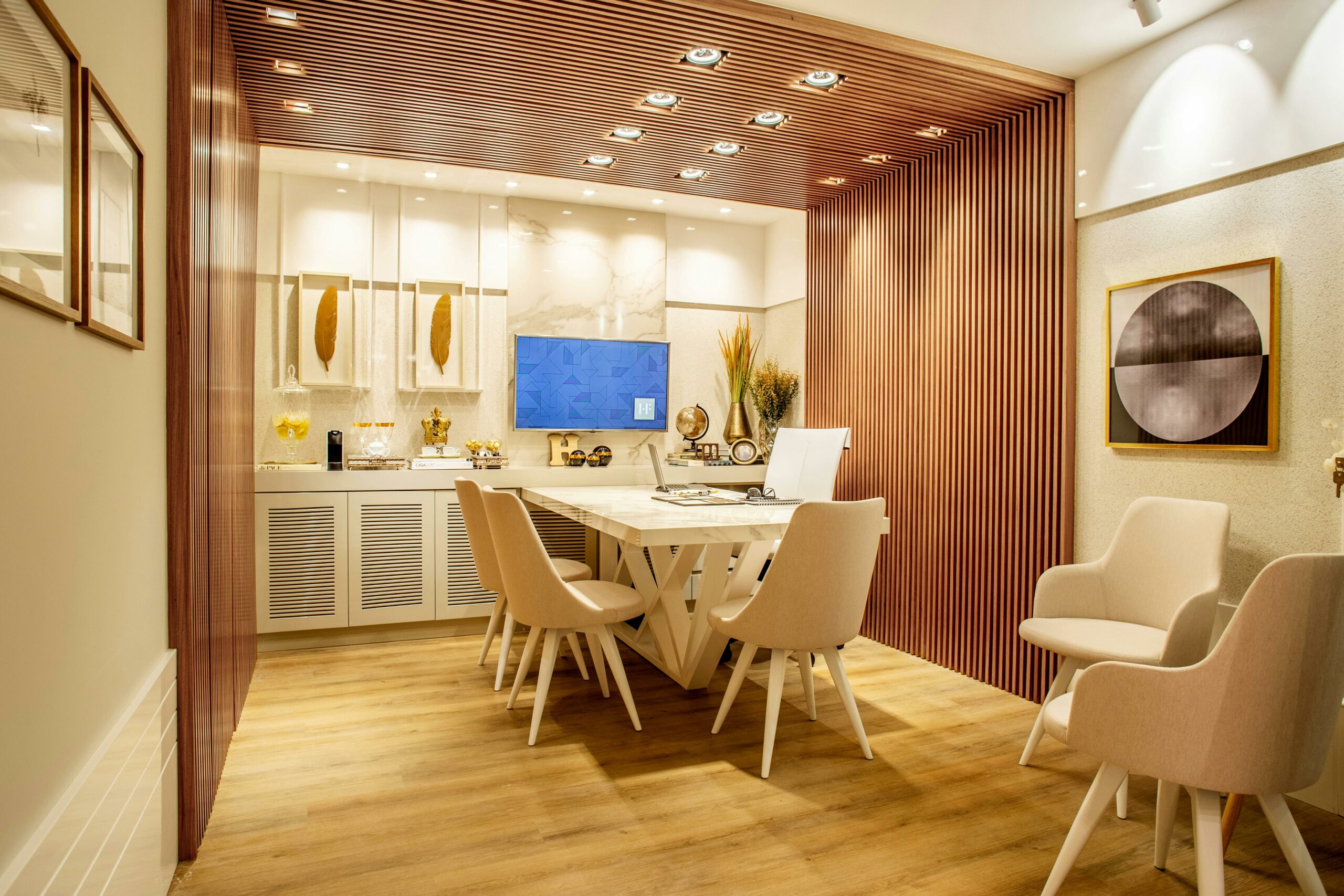Stylish dining room featuring a white dining table with chairs, textured walls with wooden slats, decorative art pieces, and a display cabinet with elegant decor items.