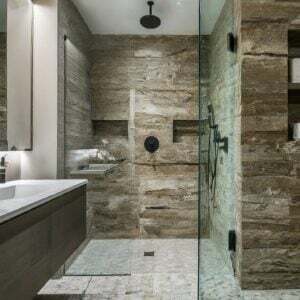 Modern bathroom with natural stone shower walls and sleek fixtures.
